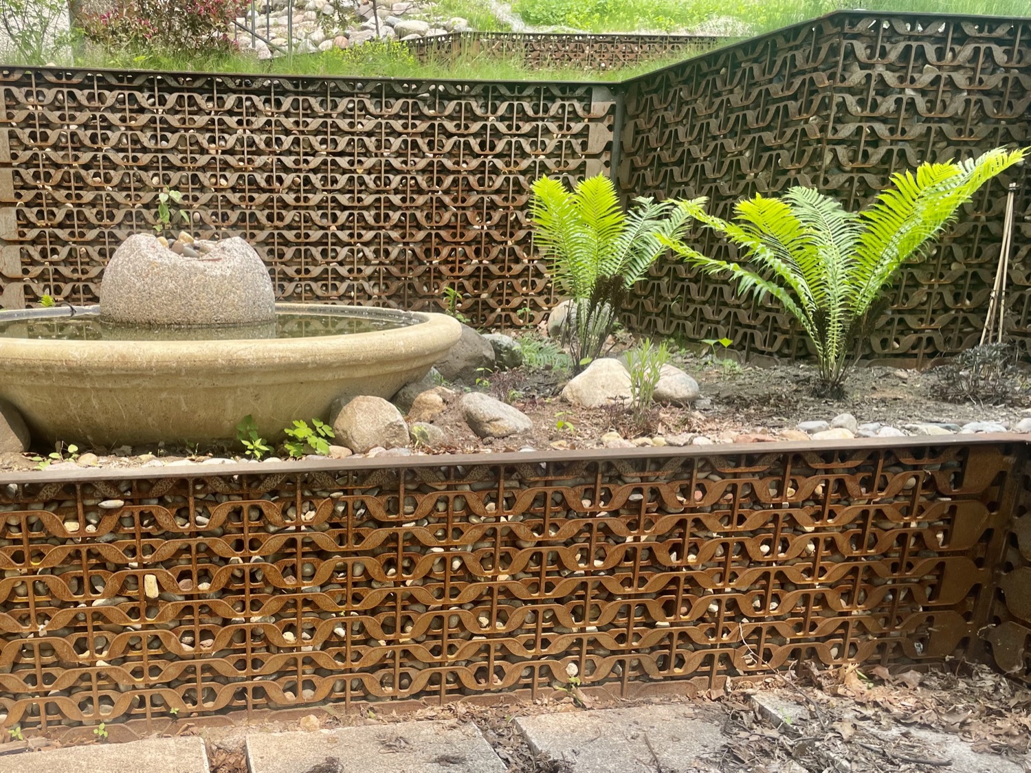 A finished stone water feature set into gabion walls