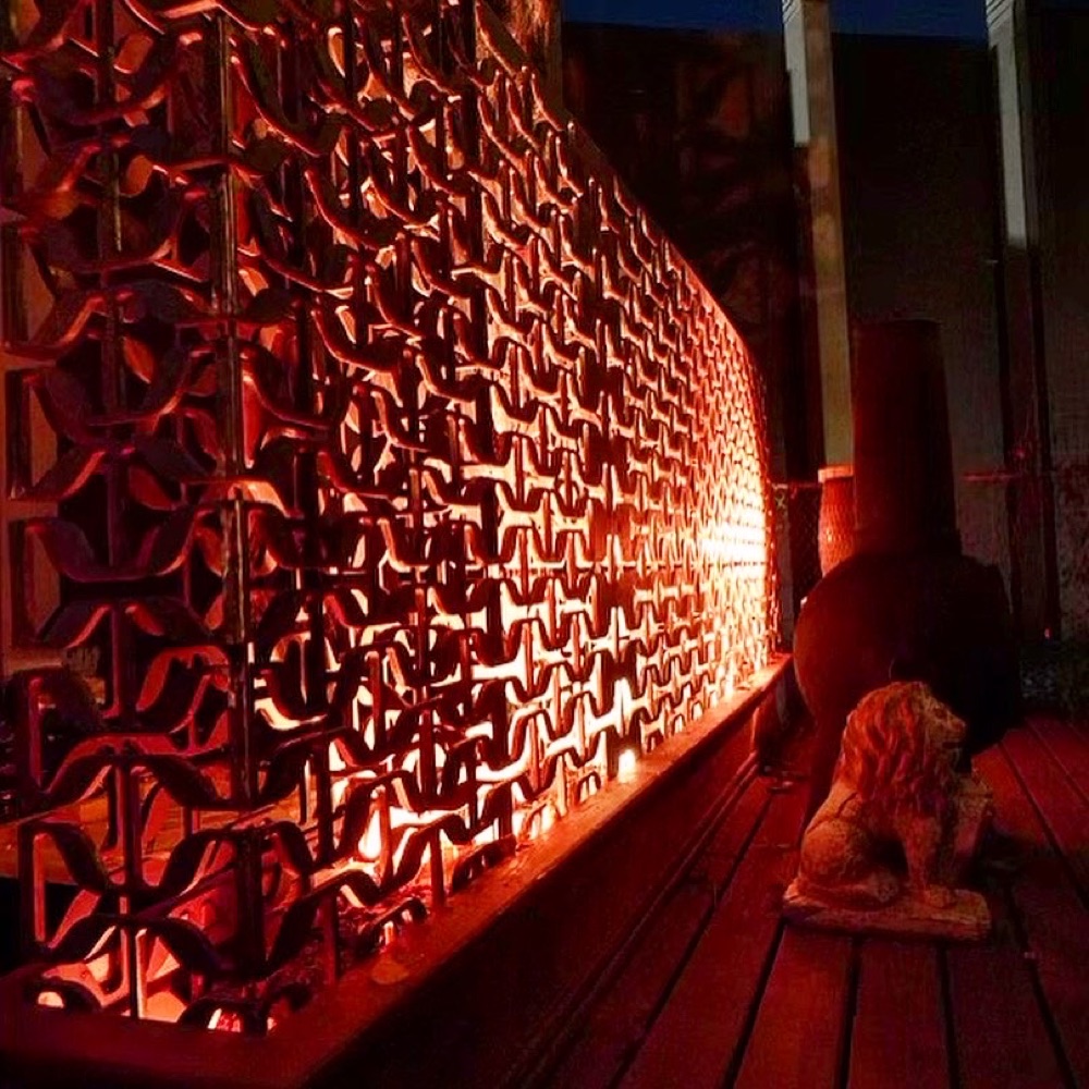Salvaged-metal screen wall lit warm